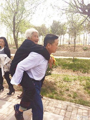 男子背老母亲景区赏梨花获赞誉老人满脸笑容